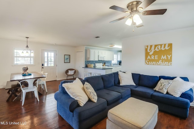 living room with ornamental molding, visible vents, dark wood finished floors, and ceiling fan