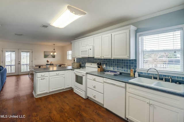 kitchen featuring white appliances, visible vents, a peninsula, french doors, and a sink