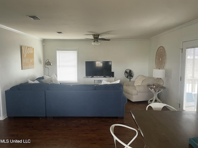 living area with visible vents, dark wood-style flooring, and ornamental molding