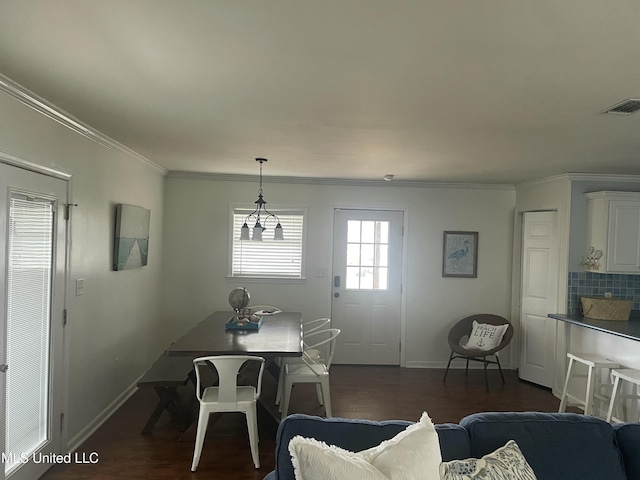 dining space featuring ornamental molding, dark wood-style flooring, visible vents, and baseboards