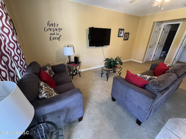 carpeted living area with baseboards, a ceiling fan, and a textured ceiling