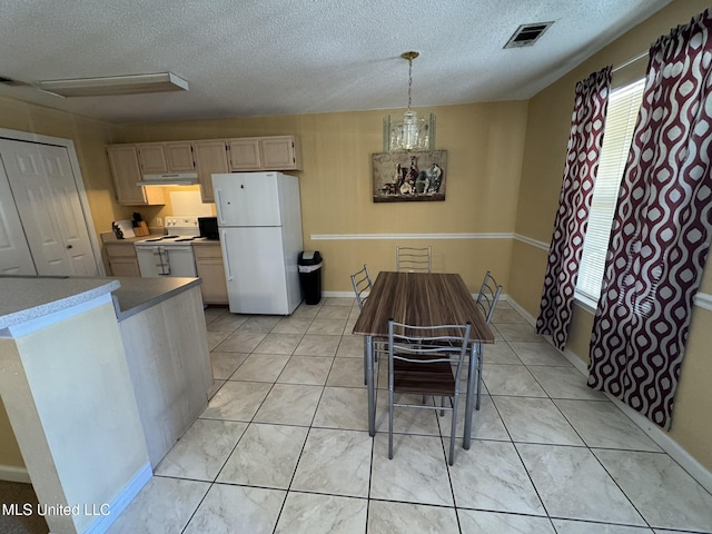 dining area featuring visible vents, a textured ceiling, and light tile patterned floors