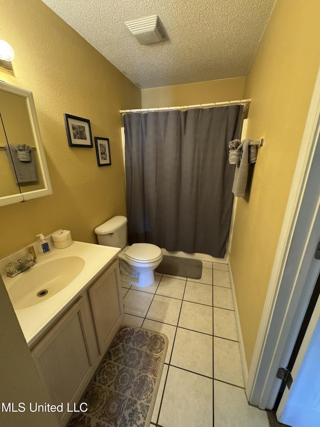 full bath with vanity, toilet, a textured ceiling, tile patterned floors, and visible vents