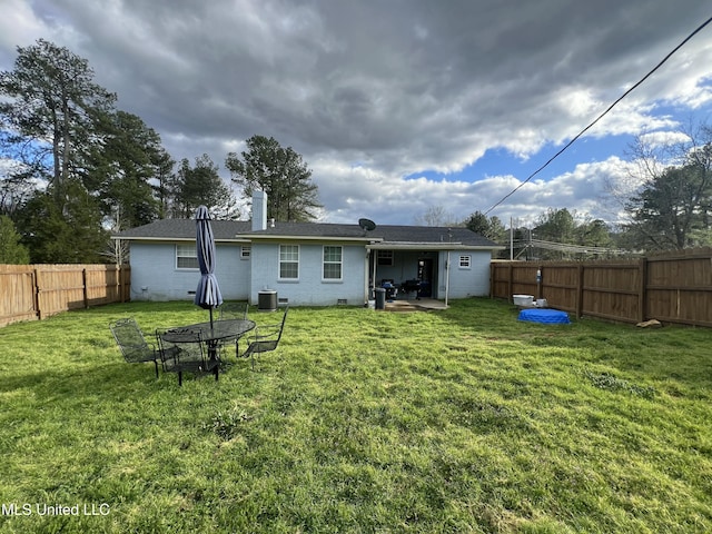 back of property with crawl space, a chimney, a fenced backyard, and central air condition unit