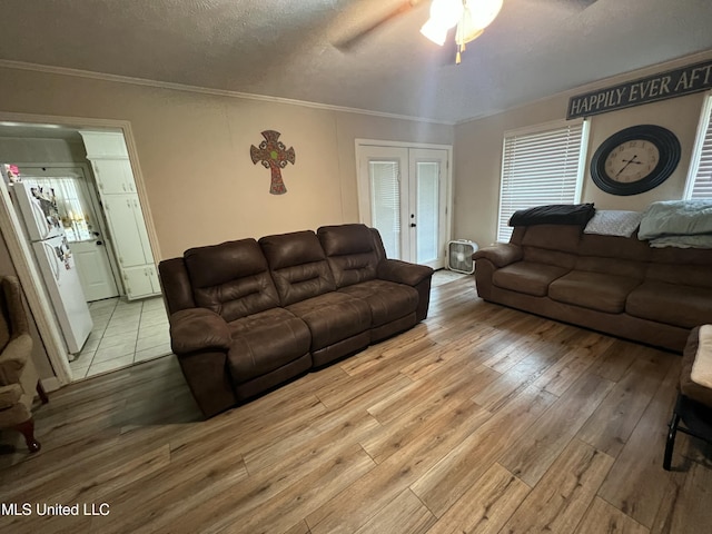 living area featuring french doors, crown molding, wood-type flooring, a ceiling fan, and a textured ceiling