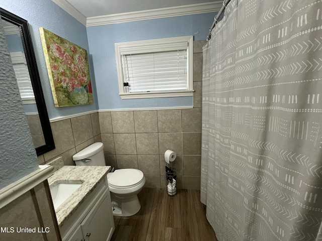 bathroom featuring tile walls, toilet, ornamental molding, vanity, and wood finished floors