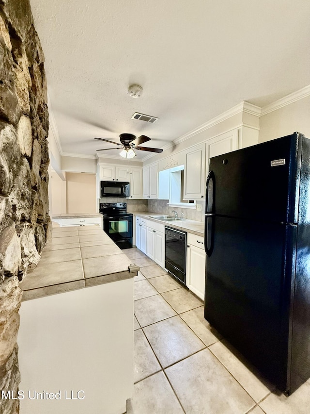 kitchen with a sink, black appliances, visible vents, and ornamental molding