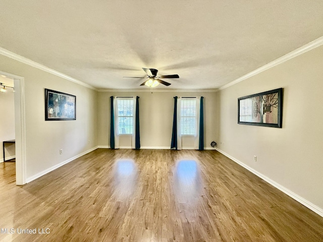 unfurnished room featuring ornamental molding, wood finished floors, baseboards, and ceiling fan