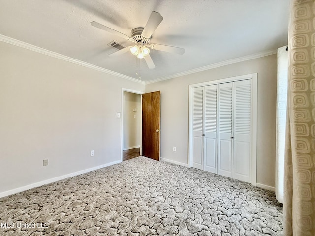 unfurnished bedroom featuring baseboards, carpet, and crown molding