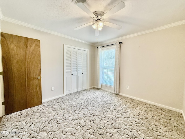 unfurnished bedroom featuring ornamental molding, a textured ceiling, baseboards, light colored carpet, and ceiling fan