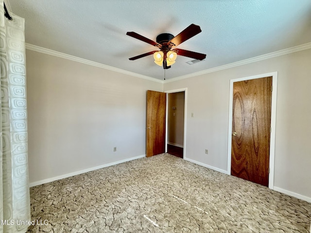 unfurnished bedroom with crown molding, ceiling fan, baseboards, carpet floors, and a textured ceiling