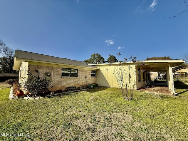 rear view of property featuring a yard and brick siding