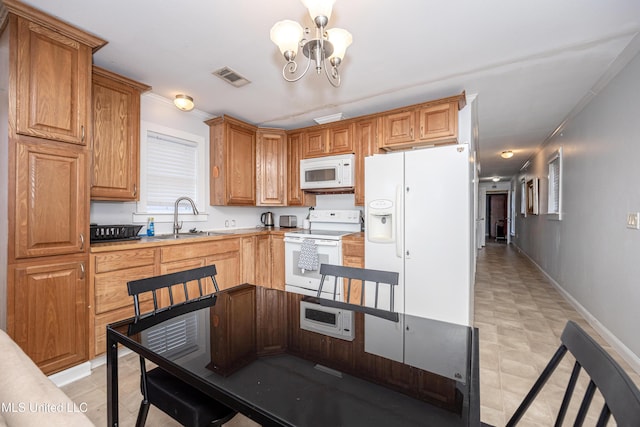 kitchen with an inviting chandelier, sink, white appliances, and ornamental molding