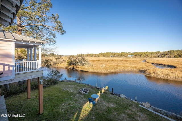 view of dock with a lawn and a water view