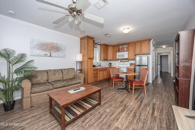 living room with ceiling fan, a textured ceiling, ornamental molding, and hardwood / wood-style floors