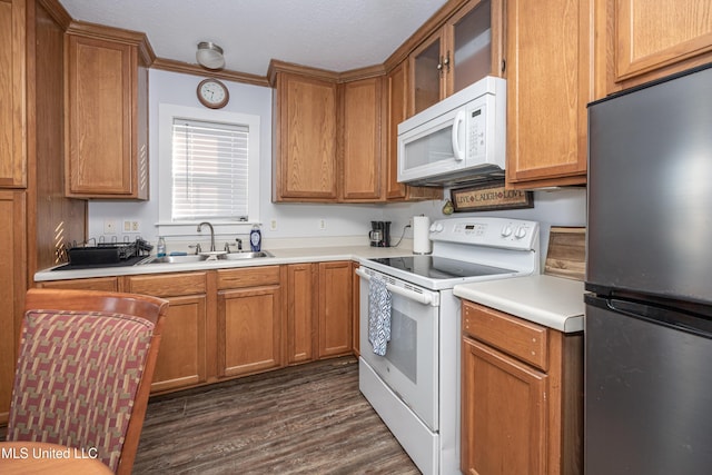 kitchen with sink, white appliances, dark hardwood / wood-style flooring, and crown molding