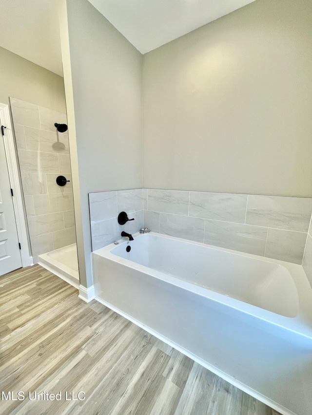 bathroom featuring hardwood / wood-style flooring and shower with separate bathtub