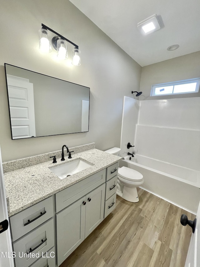 full bathroom featuring vanity, wood-type flooring, shower / bathtub combination, and toilet