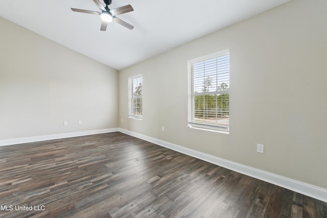 empty room featuring vaulted ceiling, ceiling fan, a wealth of natural light, and dark hardwood / wood-style floors