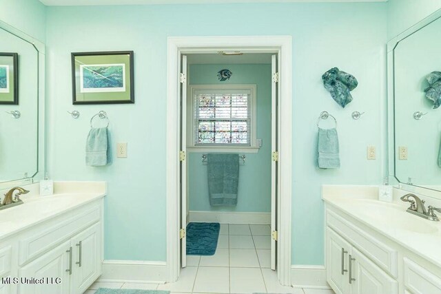 16063 W Daytona Dr, Pearlington, MS 39572 - bathroom featuring tile patterned flooring, a sink, two vanities, and baseboards
