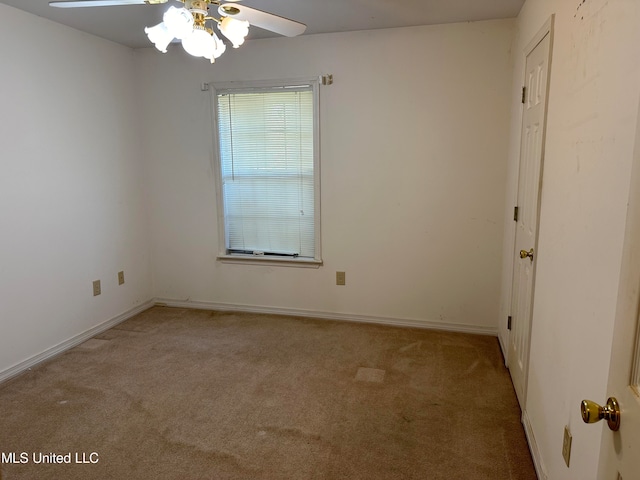 spare room featuring light carpet and ceiling fan