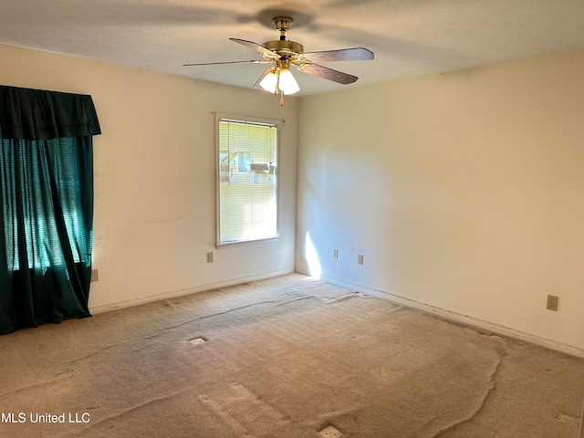 carpeted spare room featuring ceiling fan