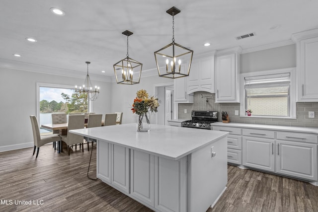 kitchen featuring visible vents, white cabinetry, a wealth of natural light, a center island, and stainless steel range with gas stovetop