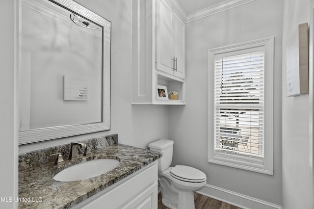 bathroom featuring ornamental molding, plenty of natural light, vanity, and toilet