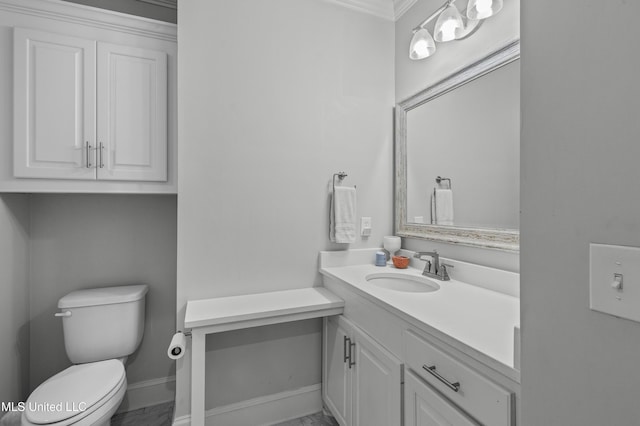 bathroom featuring baseboards, vanity, and toilet