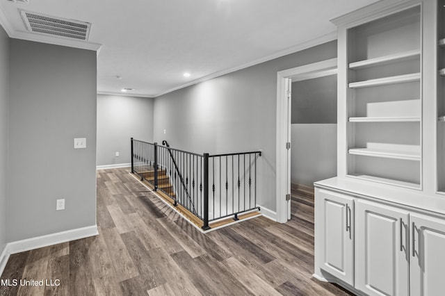 hall featuring an upstairs landing, baseboards, visible vents, dark wood finished floors, and crown molding