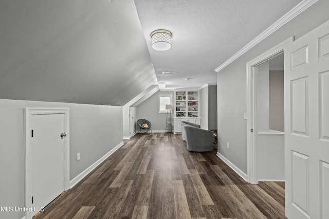 bonus room with lofted ceiling, a textured ceiling, baseboards, and wood finished floors