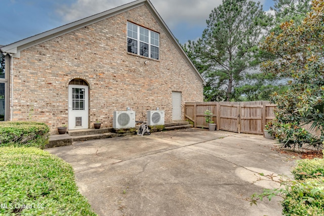 121 Poplar Ridge Dr, Brandon, MS 39047 - rear view of property featuring ac unit, a gate, brick siding, and a patio
