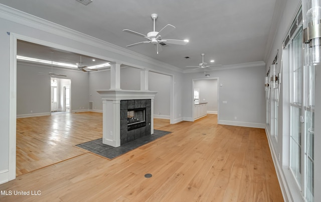 121 Poplar Ridge Dr, Brandon, MS 39047 - unfurnished living room with ceiling fan, light wood-type flooring, a tiled fireplace, baseboards, and crown molding