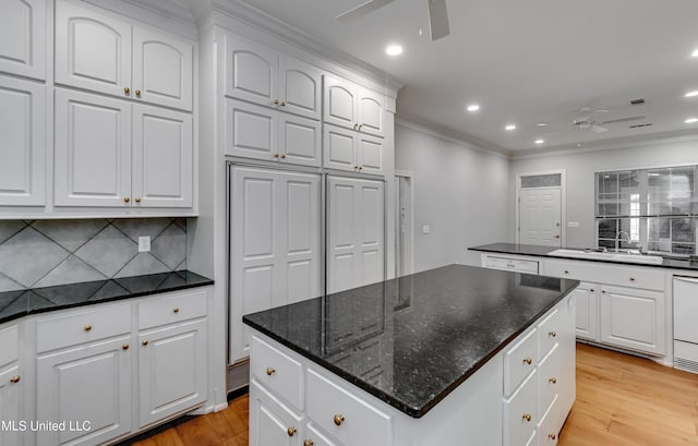 121 Poplar Ridge Dr, Brandon, MS 39047 - kitchen with a ceiling fan, a kitchen island, a sink, light wood-style flooring, and crown molding