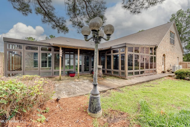 121 Poplar Ridge Dr, Brandon, MS 39047 - rear view of house with a sunroom, a patio area, a yard, cooling unit, and brick siding