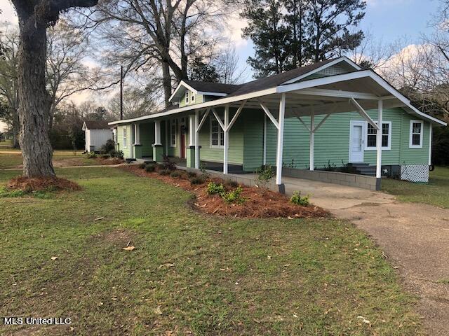 view of front of property featuring a front yard and a carport