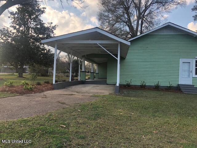 exterior space featuring a carport and a lawn