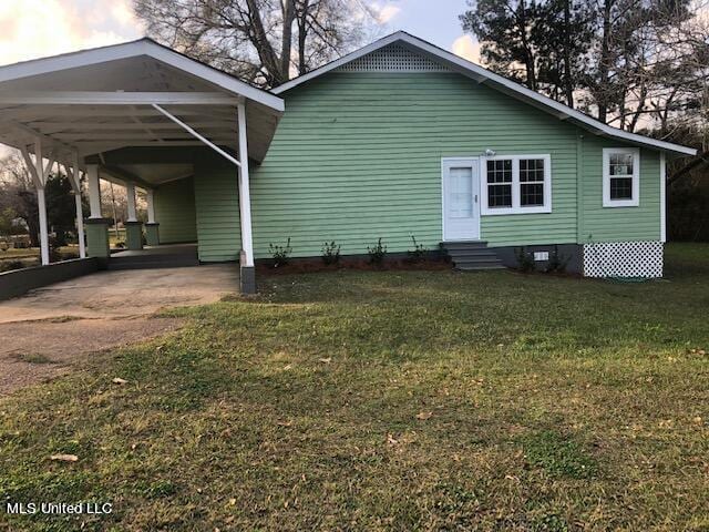 view of front of property featuring a front lawn and a carport