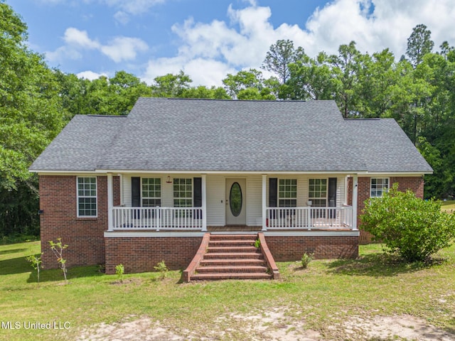 view of front of property with a porch, roof with shingles, a front yard, and brick siding