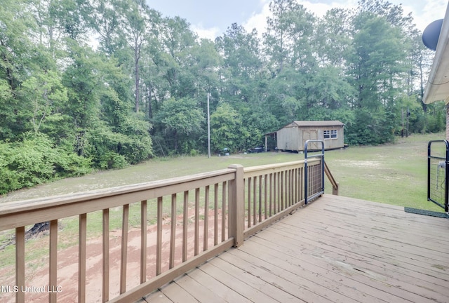 wooden deck with a storage unit, a lawn, and an outdoor structure