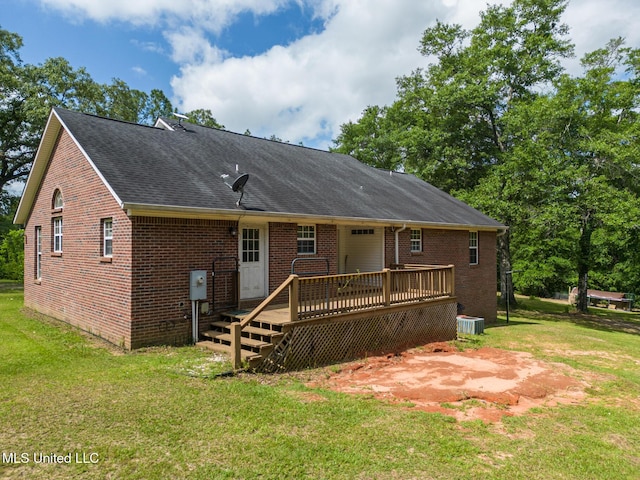 rear view of house with a deck, brick siding, a yard, and a shingled roof