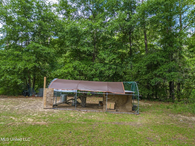 view of green lawn with exterior structure and an outbuilding
