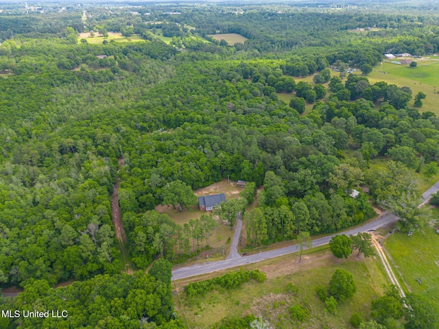 aerial view of property and surrounding area with a heavily wooded area