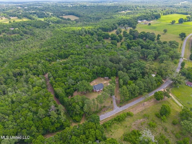 aerial view of property and surrounding area featuring a forest