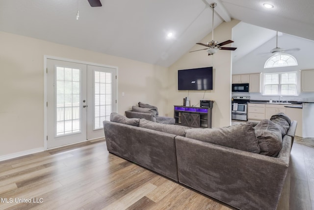 living room featuring a ceiling fan, beam ceiling, light wood-style floors, french doors, and high vaulted ceiling