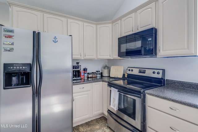 kitchen featuring stainless steel appliances, dark countertops, and white cabinetry