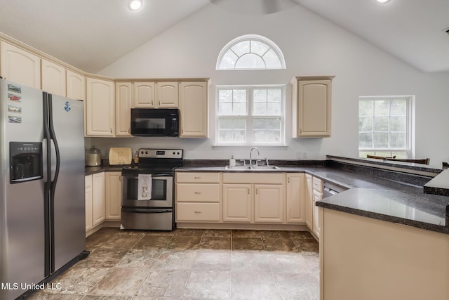 kitchen featuring appliances with stainless steel finishes, a sink, high vaulted ceiling, dark countertops, and healthy amount of natural light