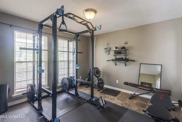 workout room featuring baseboards