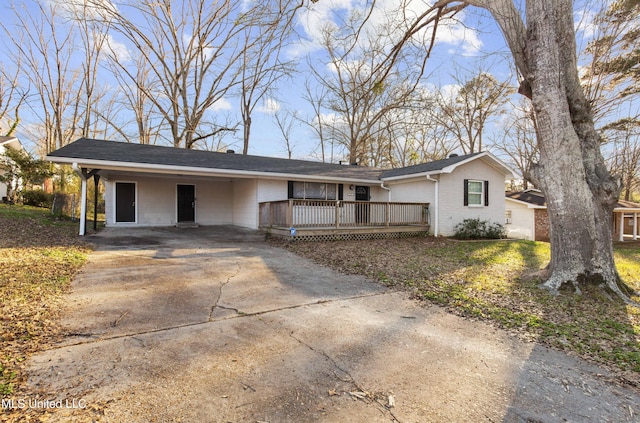 ranch-style home with a carport, driveway, brick siding, and a wooden deck