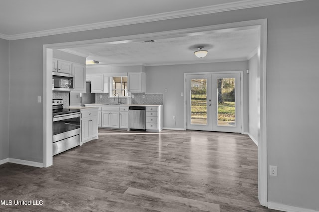 kitchen featuring stainless steel appliances, white cabinetry, a sink, and crown molding